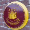 Handmade claret and yellow circular sign with the West Ham Football Club badge.