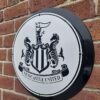 Handmade black and white circular sign with the Newcastle United Football Club badge.